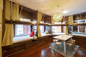 a room with bunk beds and a table and chairs at OYO 895 The Onion Hostel in Bangkok