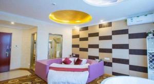 GreenTree Inn Wuxi Donggang Town Donghutang Shell Hotel في ووشي: غرفة معيشة مع أريكة أرجوانية وجدار مربّع