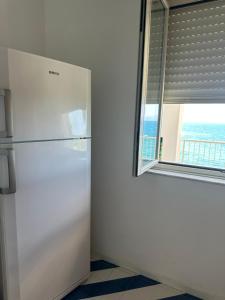 a white refrigerator in a room with a window at Oltremare in Brucoli