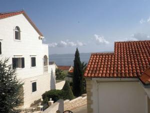 a white building with a garage next to a house at Apartmani Franceska in Bol