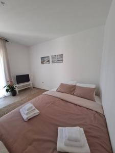 a bedroom with a large bed with two towels on it at Galeb in Igalo