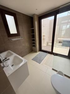 a bathroom with a sink and a large window at Ocean Breeze Hawana in Salalah +16 photos