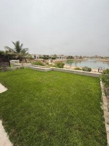 a green lawn with a view of a body of water at Ocean Breeze Hawana in Salalah