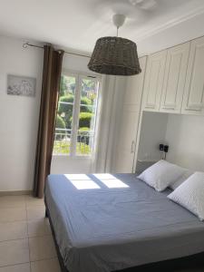 une chambre avec un grand lit avec une fenêtre dans l'établissement Les Jasmins, à La Croix-Valmer