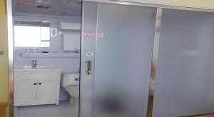 e bagno con servizi igienici e porta doccia in vetro. di Shell Nanjing City Qixia District Baguazhou Hotel a Nanjing Altre 63 foto