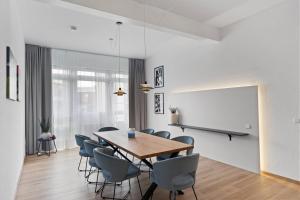 una sala da pranzo con tavolo, sedie e parete bianca di Anytime - Ferienwohnungen am Uferpark direkt am See a Friedrichshafen