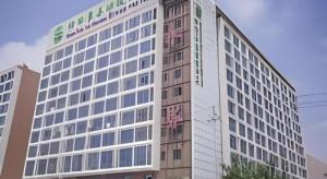 een hoog gebouw met een bord aan de zijkant bij GreenTree Inn Suqian Suyu District Red Star Macalline in Zhuoxu