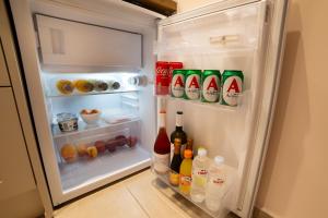 an open refrigerator filled with bottles and drinks at Nissos Apartments in Myrina