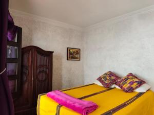 a yellow bed with two pillows on top of it at Casa Feliz Antigua in Antigua Guatemala