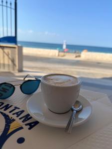 een kopje koffie zittend op een tafel bij het strand bij Casa Mare Salento - a due passi dal mare in Marina di Lizzano +56 foto's