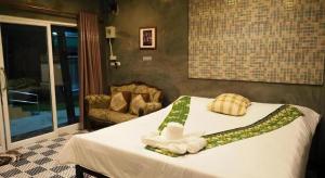 a bedroom with a bed with towels on it at Nawamit Home Garden in Nakhon Si Thammarat