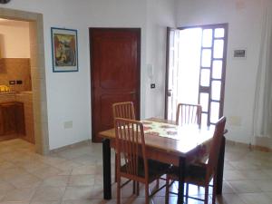 a dining room with a wooden table and chairs at Casavacanze Antonio in Leuca +9 photos