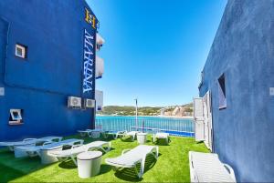 un groupe de chaises et de tables sur le côté d'un bâtiment dans l'établissement Hotel Marina, à Oropesa del Mar