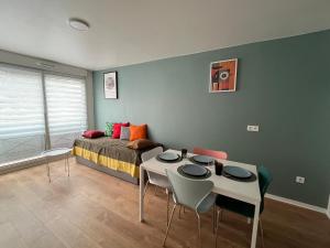 a bedroom with a bed and a table and chairs at PERLE HDG Tout Confort in La Courneuve