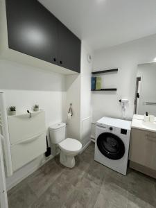a bathroom with a toilet and a washing machine at PERLE HDG Tout Confort in La Courneuve