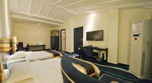 une chambre d'hôtel avec deux lits et une télévision dans l'établissement Guilin Sapphire hotel, à Guilin