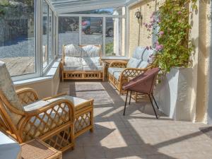 un portico con sedie a dondolo e finestre di Sanctuary Cottage ad Aberdaron
