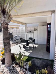 un patio con tavolo, sedie e palma di Ocean view a Puerto Rico de Gran Canaria