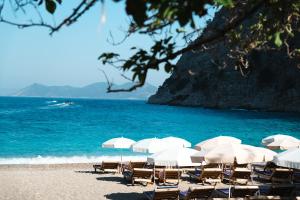a group of chairs and umbrellas on a beach at Butterfly Valley Beach Glamping in Fethiye