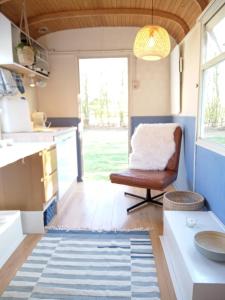 a kitchen and living room in a tiny house at Heerlijk relaxen, knusse accommodatie vlakbij zwemplas in Vierakker