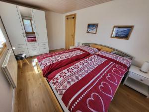 a bedroom with a bed with a red and white comforter at Uf em Schloss in Biel