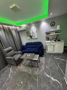 a living room with a blue couch and a green ceiling at Apartman S&V 2 Istocno Sarajevo Lukavica sa Jacuzzi Lux Spa Hilandarska Centar in Lukavica