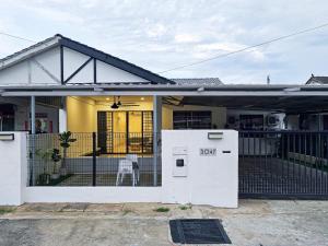 a house with a refrigerator in the front yard at VV Rooms in Tawau