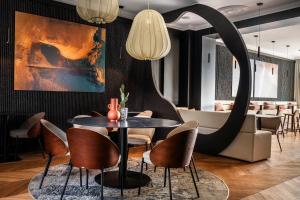 a dining room with a table and chairs at Hotel & Spa Les Roches Noires in Les Sables-d'Olonne