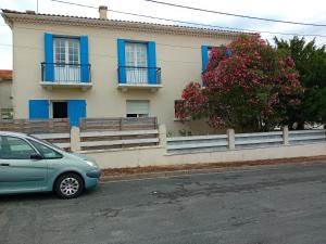 a blue car parked in front of a house at Pluie de roses in Royan
