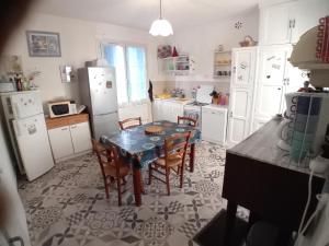 a kitchen with a table and chairs and a refrigerator at Pluie de roses in Royan +9 photos