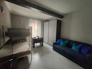 a living room with a blue couch and a bed at House Venus in Le Grazie