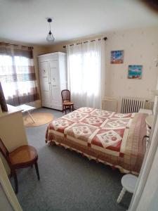 a bedroom with a bed and two chairs in it at Pluie de roses in Royan