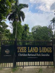 索拉哈Hotel Tree Land Lodge and Cottage的篱笆上的树木土地小屋标志