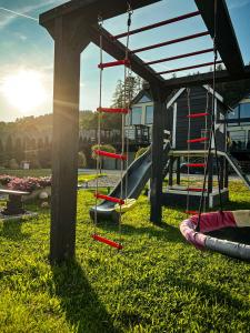 a playground with a slide and a swing set at Dream Hill - Dom Premium z jacuzzi oraz sauną w cenie i na wyłączność in Jazowsko