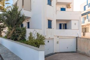 a white building with a white gate and a fence at Charmante ferienwohnung in Tinos Town