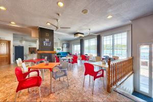 ein Restaurant mit roten Stühlen und Tischen in einem Zimmer in der Unterkunft Hotel Marina in Oropesa del Mar