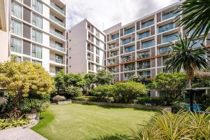 a garden in front of a large apartment building at The Nimmana Condo 410 - Super Deluxe 1BR Balcony extension in Chiang Mai