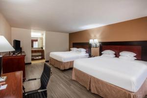 Giường trong phòng chung tại Days Inn & Suites by Wyndham Tyler