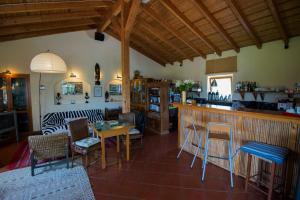 a living room with a counter and a bar with chairs at Casa Vicentina in Odeceixe