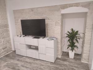 a living room with a television on a white cabinet at Il canto del mare in Giovinazzo