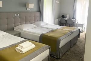 a bedroom with two beds with towels on them at Hotel Aqua Sopot - Destigo Hotels in Sopot