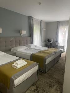 a bedroom with two beds and a desk at Hotel Aqua Sopot - Destigo Hotels in Sopot