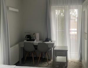 a desk with two chairs in a room with a window at Hotel Aqua Sopot - Destigo Hotels in Sopot
