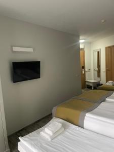 a hotel room with two beds and a flat screen tv at Hotel Aqua Sopot - Destigo Hotels in Sopot