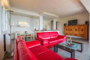 a living room with a red couch and a table at Casa Cora in Agra
