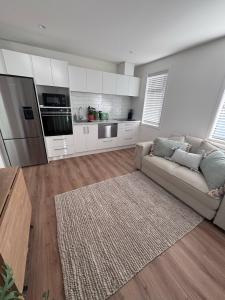 a living room with a couch and a kitchen at One bedroom apartment in Queenstown Airport