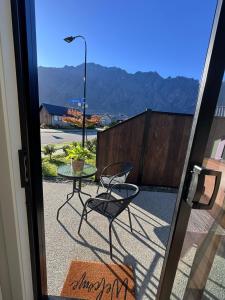 a glass door with a table and a chair on a patio at One bedroom apartment in Queenstown Airport +6 photos