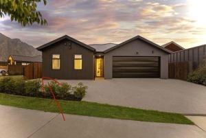 a house with a garage in a driveway at One bedroom apartment in Queenstown Airport