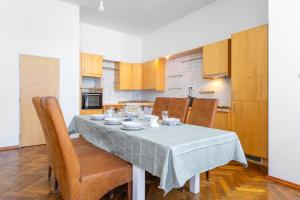a dining room table with chairs and a table cloth on it at Rooftop Flower Power Apartment in Brno