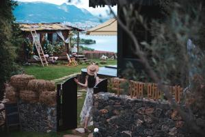 a woman in a hat standing behind a fence at Lijiang Jijian Xiangwang SOOOAN Luxury Resort Hotel in Lijiang